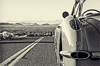 Side view of a 1950s corvette on the road facing into the horizon
