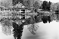 A very calm lake with an old historic house on the bank