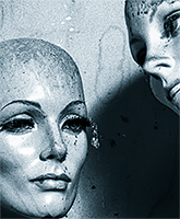 One mannequin looking at another mannequin with a tear dropping from her eye.