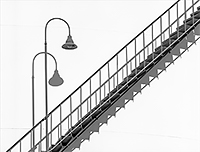 Stairs and a lamp with shadow against a white tank